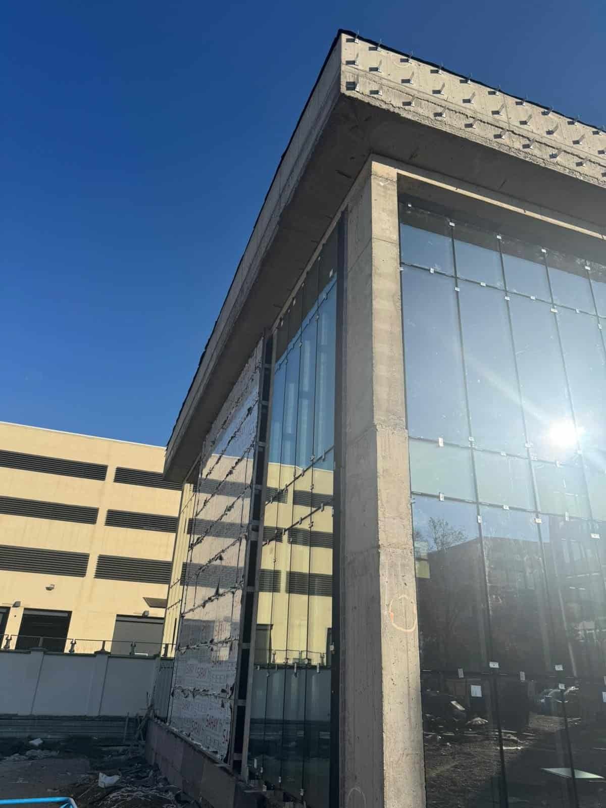 Clădire modernă cu fațadă din sticlă și beton, realizată de montajsticla.ro pentru proiecte de calit.